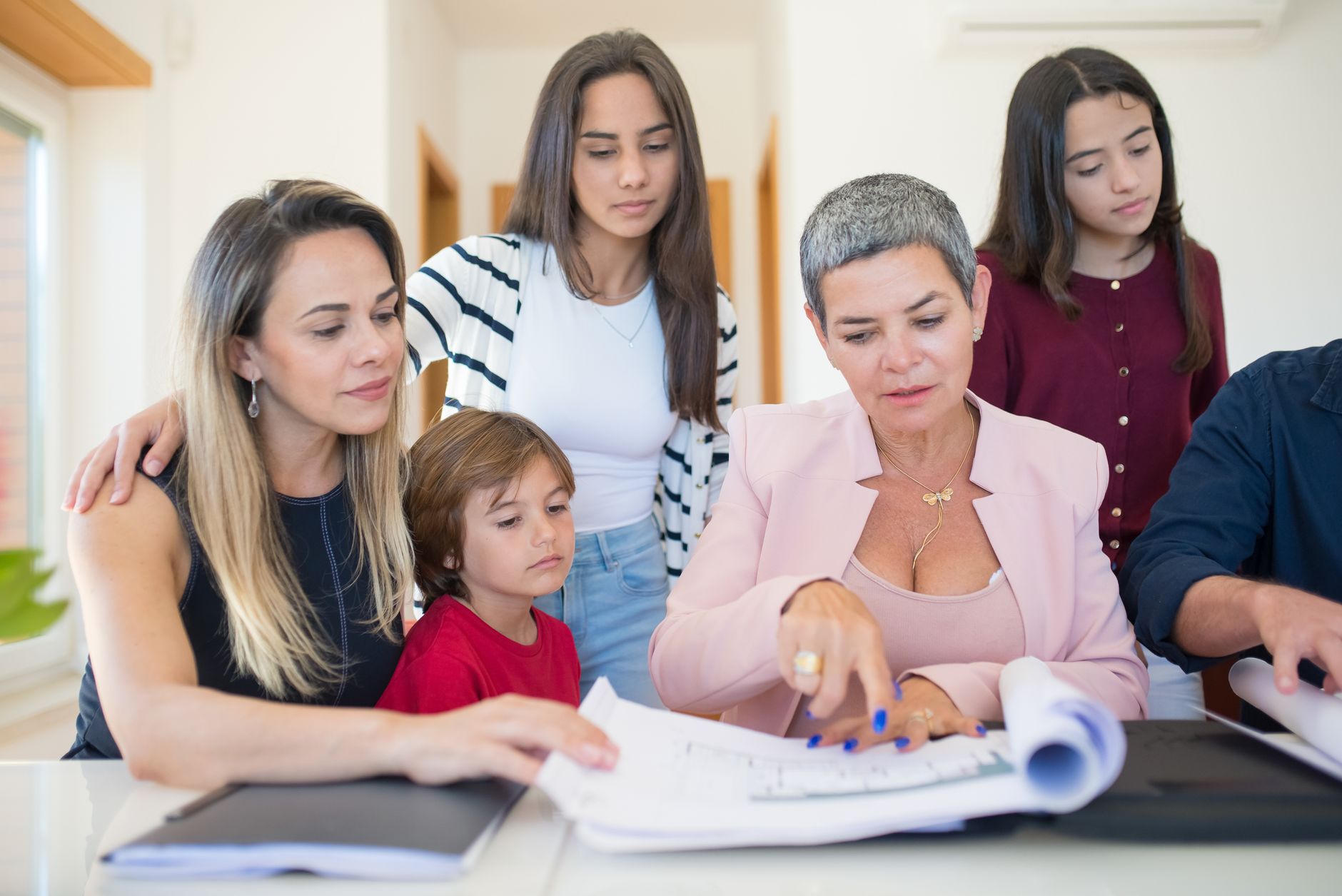 Família a rever documentos com uma consultora, em casa